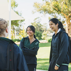 Students standing in a group together outside chatting.